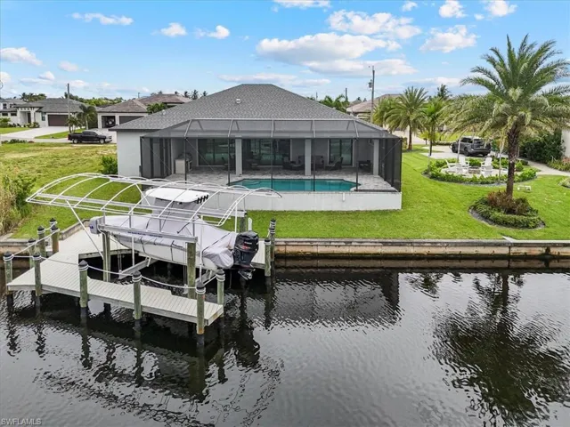 Dock area with a yard, an outdoor pool, a lanai, and boat lift