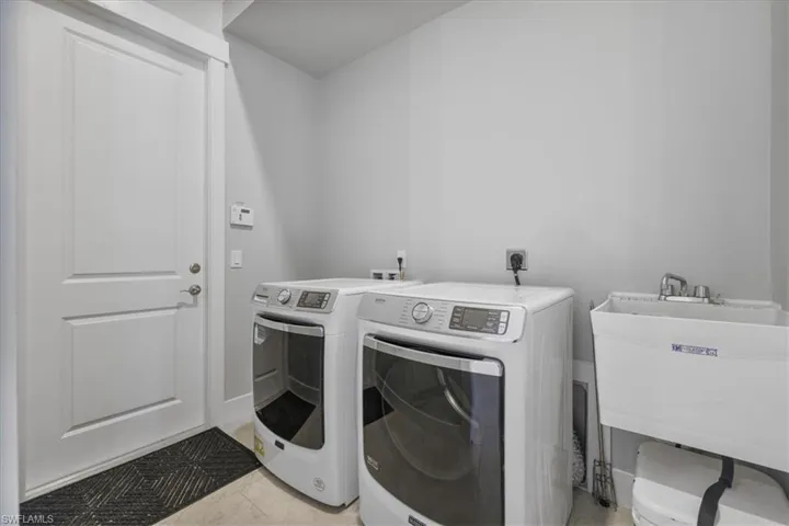 Laundry room featuring separate washer and dryer and light tile patterned floors