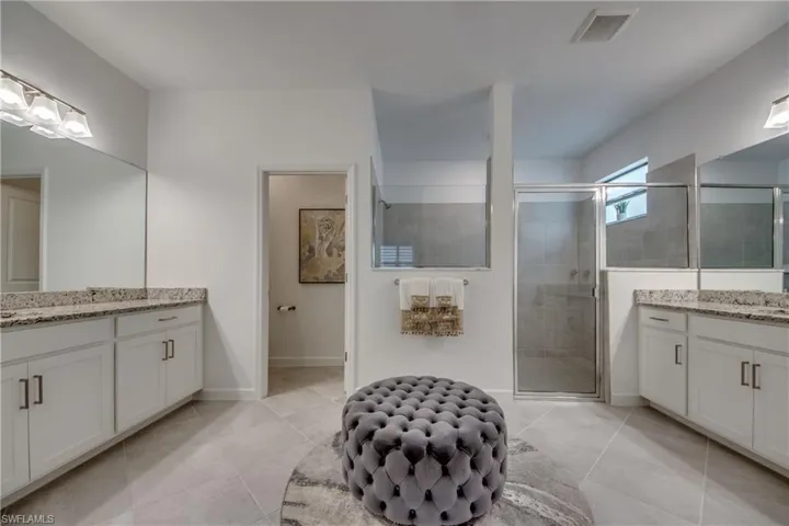 Bathroom with tile patterned floors, an enclosed shower, and vanity