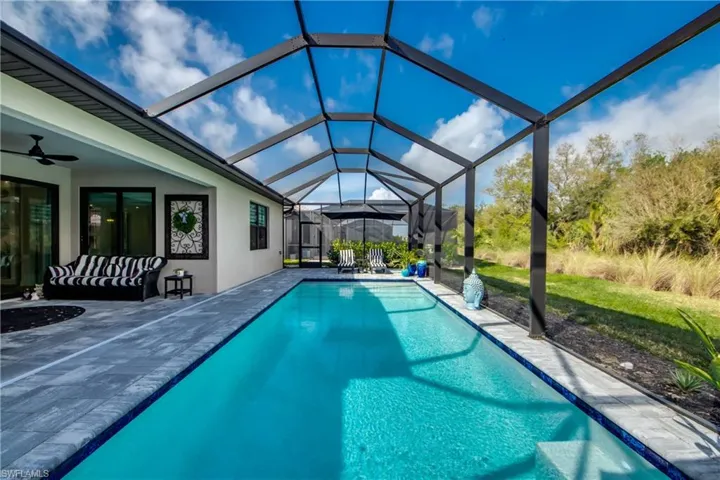 View of pool with a patio area, a lanai, and ceiling fan