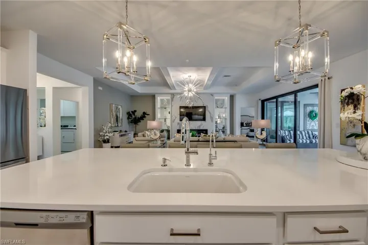 Kitchen with sink, dishwasher, fridge, washer / dryer, and pendant lighting