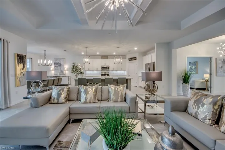 Living room with light tile patterned flooring and a chandelier