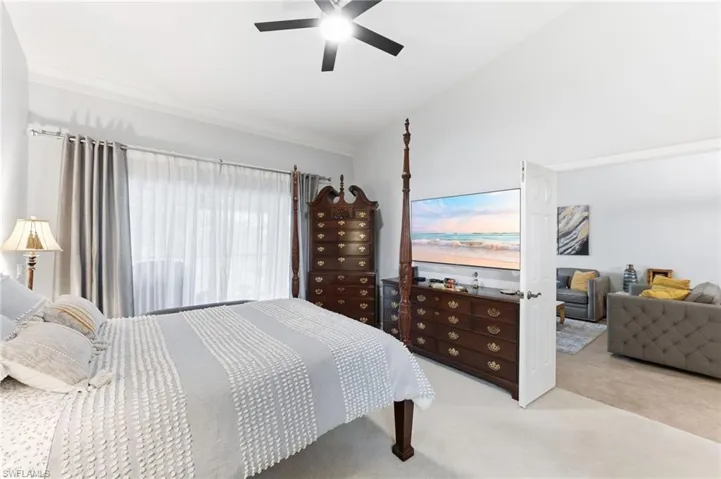 Carpeted bedroom with lofted ceiling and a ceiling fan