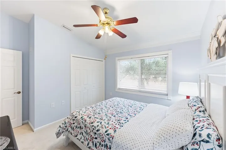 Bedroom with light carpet, vaulted ceiling, a closet, and ceiling fan