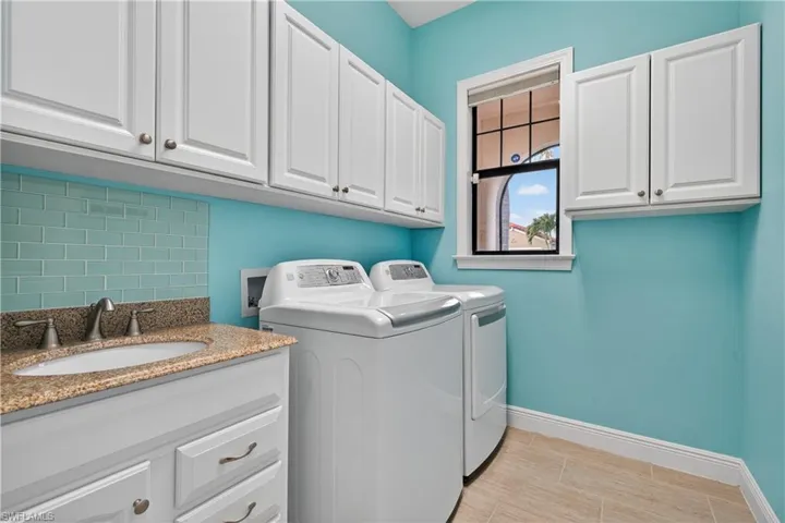 Laundry room featuring sink, plenty of cabinets, washer and dryer