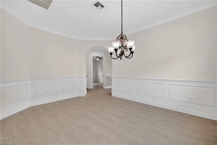 Flex room with hand crafted wainscoted walls and arched walkways.  This room can be used as a formal dining room, office, den or hobby room.