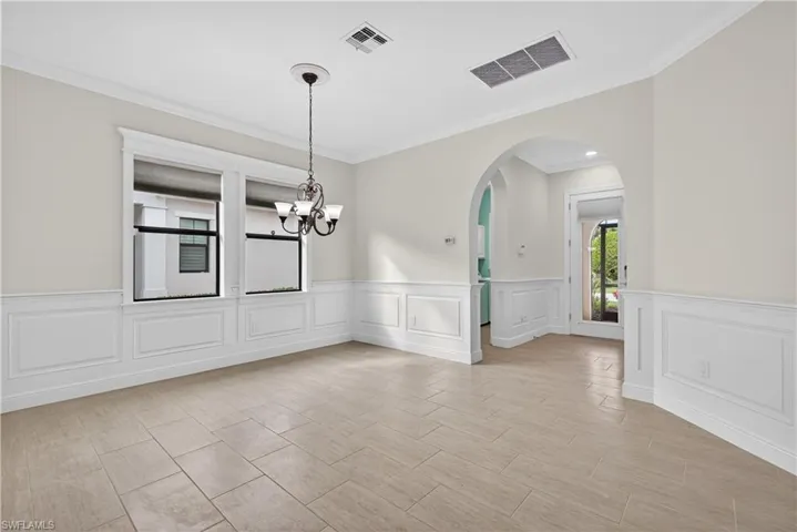 Flex room with hand crafted wainscoted walls and arched walkways.  This room can be used as a formal dining room, office, den or hobby room.