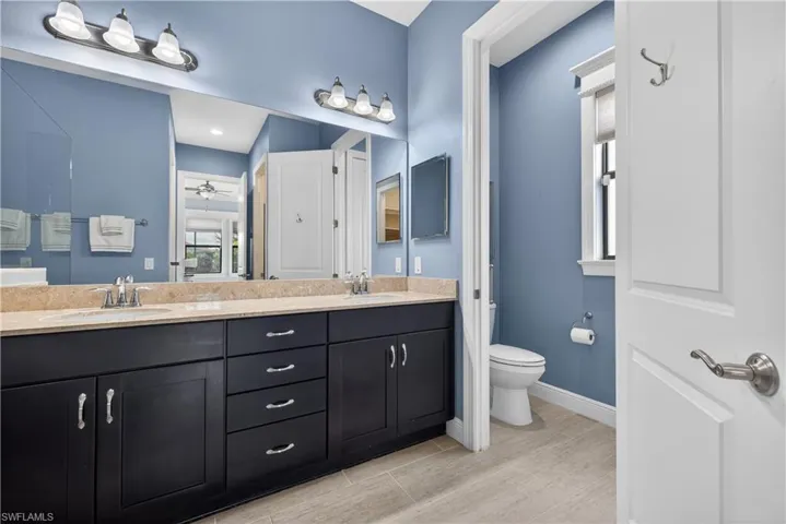 Bathroom with double vanity and a ceiling fan