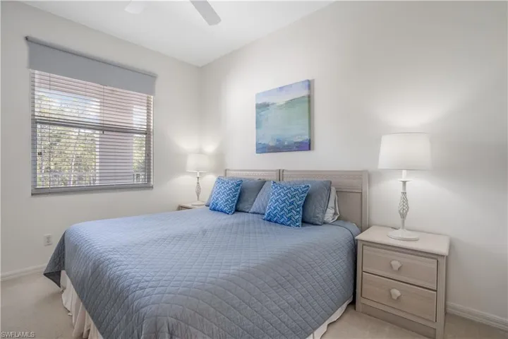 Carpeted bedroom featuring ceiling fan