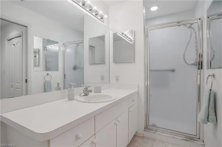 Bathroom with tile patterned flooring, vanity, and an enclosed shower