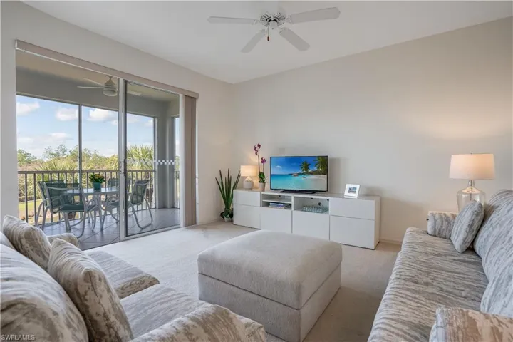 Living room featuring ceiling fan and light colored carpet
