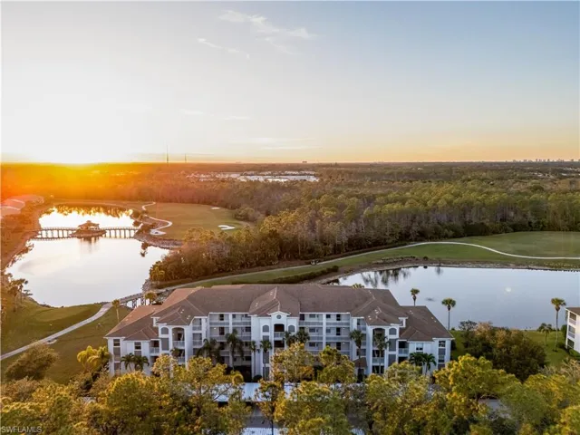 Aerial view at dusk featuring a water view