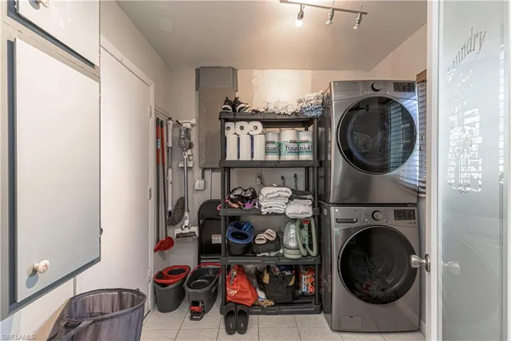 Laundry room featuring laundry area, stacked washer / dryer, and tile patterned floors