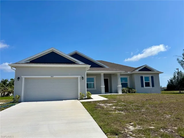 Single story home featuring stucco siding, concrete driveway, an attached garage, and a front lawn