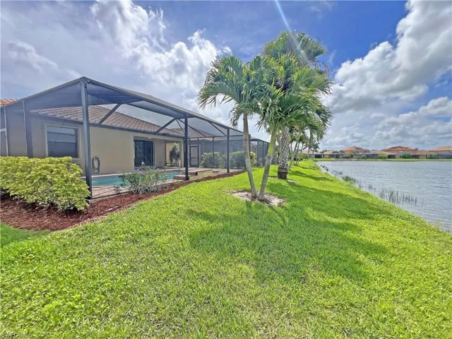 View of yard featuring lanai and a lake view
