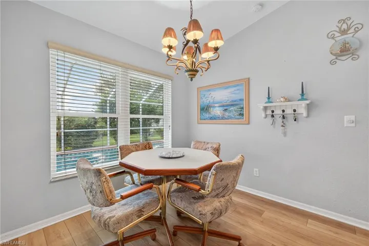 Dining room with a chandelier, light wood finished floors, and lofted ceiling