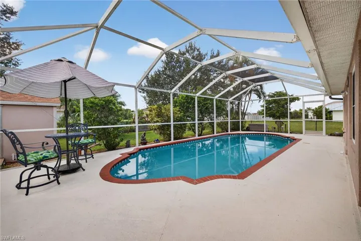 Outdoor pool with glass enclosure, a patio, and a sunroom