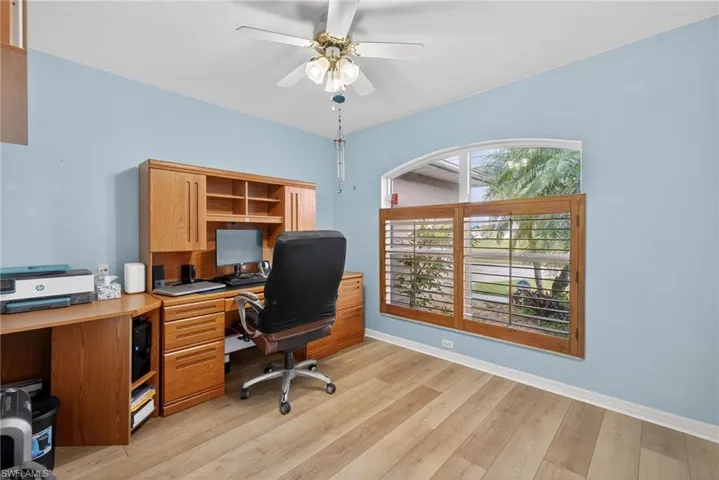 Office area with light wood finished floors and ceiling fan
