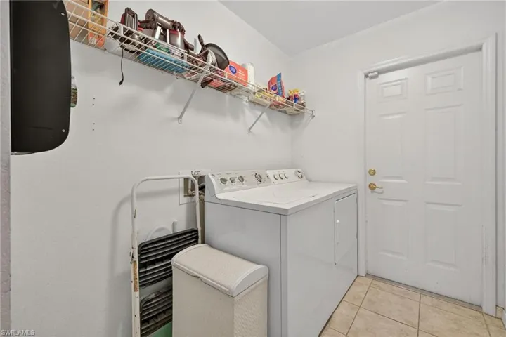 Laundry room with light tile patterned floors and hookup for a washing machine