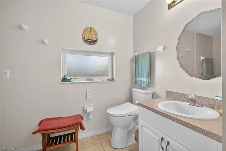 Full bath featuring vanity, light tile patterned flooring, and a shower
