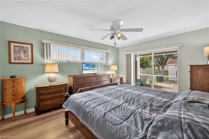 Bedroom featuring wood finished floors, access to exterior, and ceiling fan