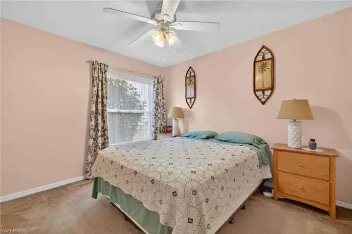 Carpeted bedroom with baseboards and ceiling fan