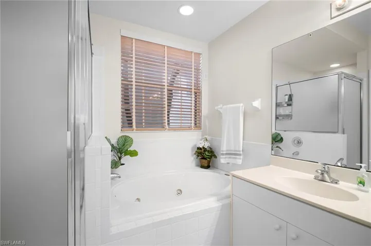 Bathroom featuring a whirlpool tub, vanity, a shower stall, and recessed lighting