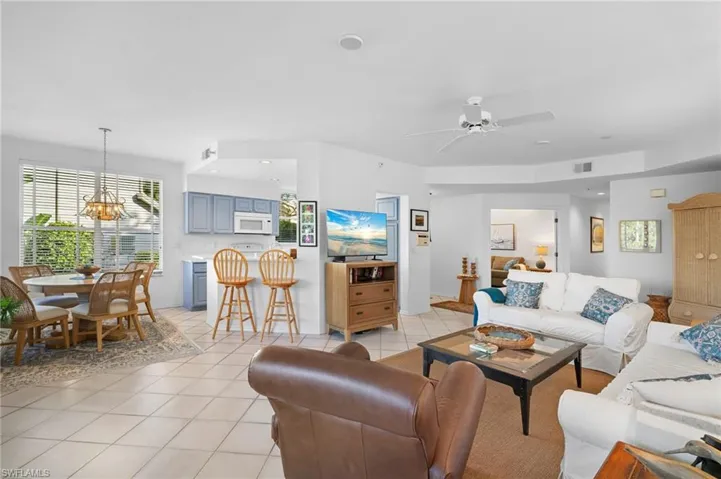Living room featuring light tile patterned floors, a chandelier, a ceiling fan, and recessed lighting