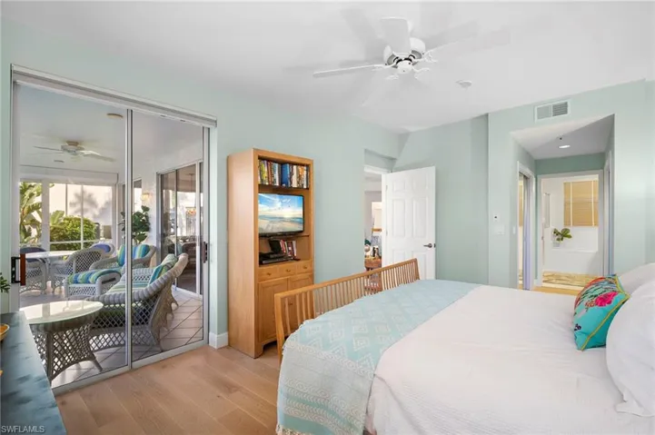 Bedroom featuring a ceiling fan, Mirage wood flooring, and access to exterior