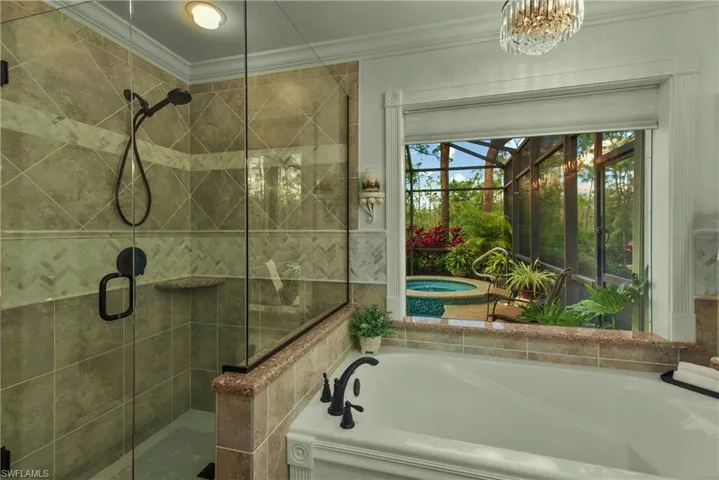 Full bath with a stall shower, a garden tub, and crown molding