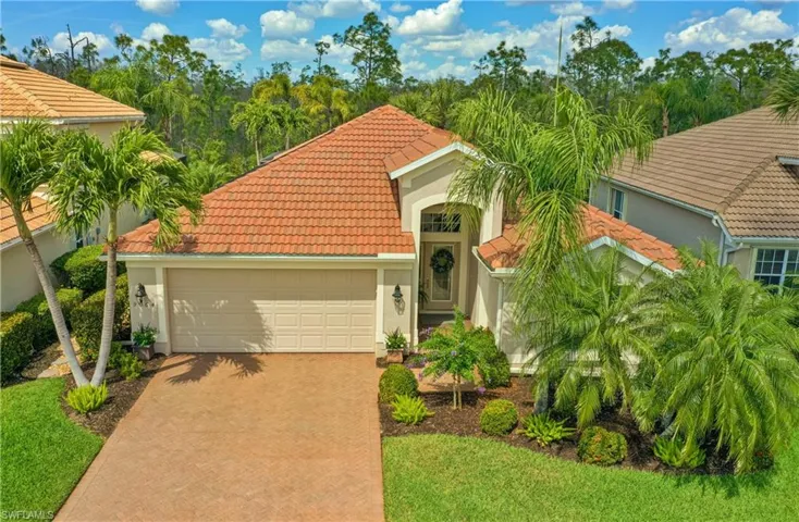 Mediterranean / spanish house with a tiled roof, decorative driveway, an attached garage, and stucco siding