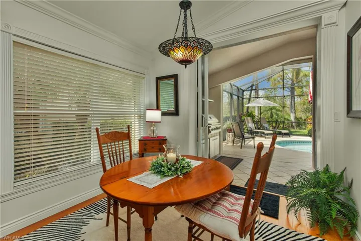 Tiled dining space featuring a sunroom and ornamental molding