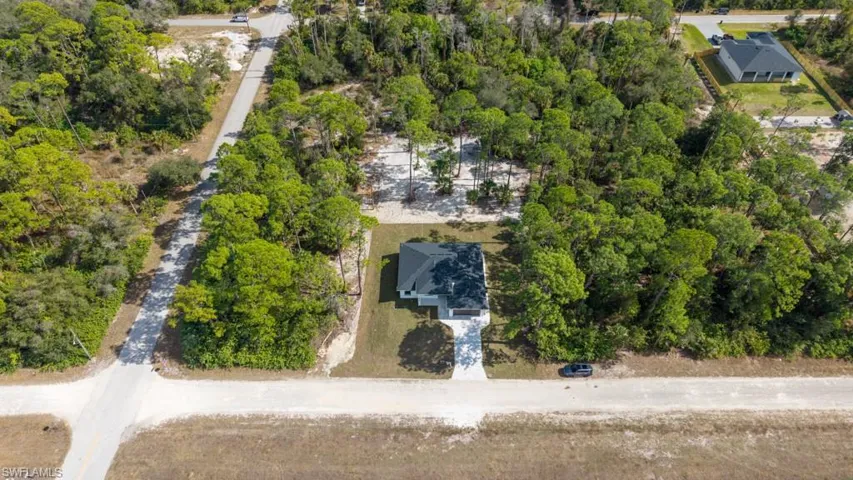 Aerial view of property's location with a tree filled landscape