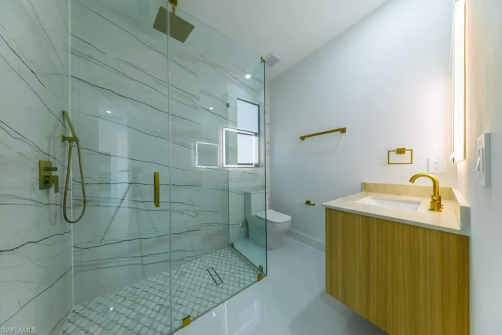 Bathroom with a marble finish shower and vanity