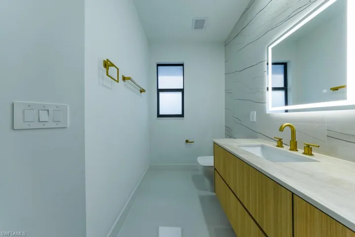 Half bath featuring vanity and tasteful backsplash