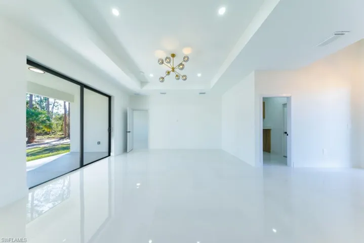 Unfurnished room featuring a chandelier, recessed lighting, a tray ceiling, and light tile patterned flooring