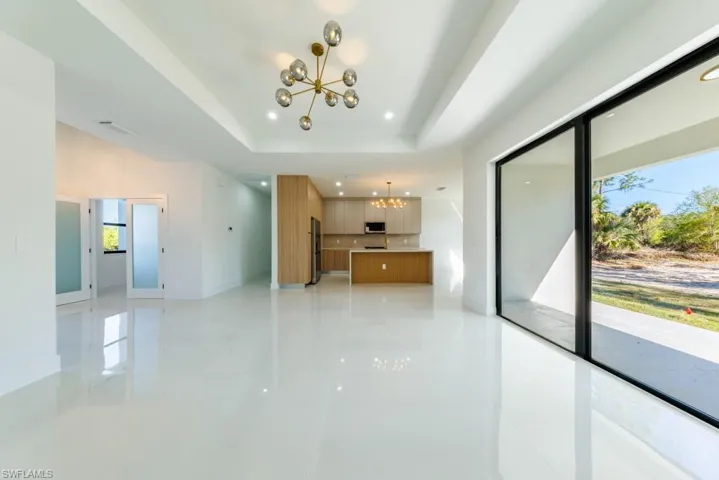 Unfurnished living room featuring a chandelier and recessed lighting