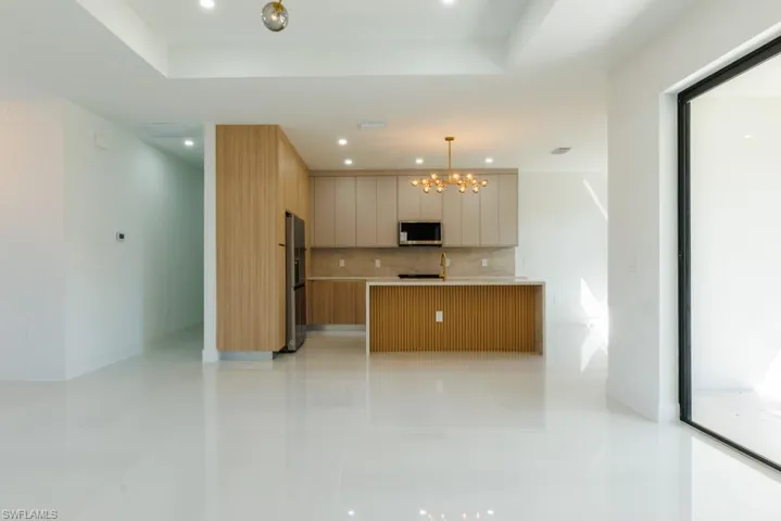 Kitchen with modern cabinets, hanging light fixtures, a chandelier, appliances with stainless steel finishes, and recessed lighting