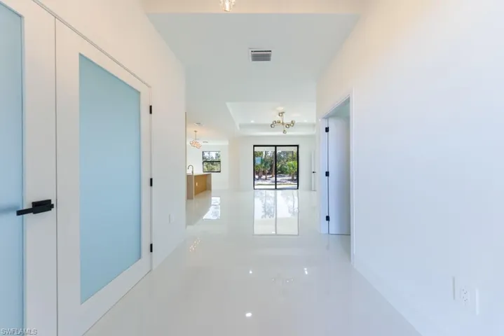 Hallway with a chandelier and a tray ceiling