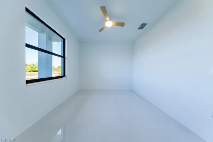 Unfurnished room with ceiling fan and baseboards