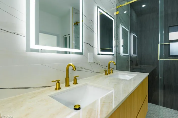 Bathroom with double vanity, a stall shower, and decorative backsplash