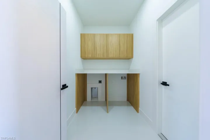 Laundry area featuring electric dryer hookup and cabinet space