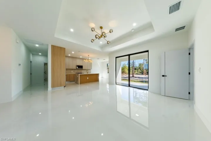 Unfurnished living room featuring a chandelier and recessed lighting