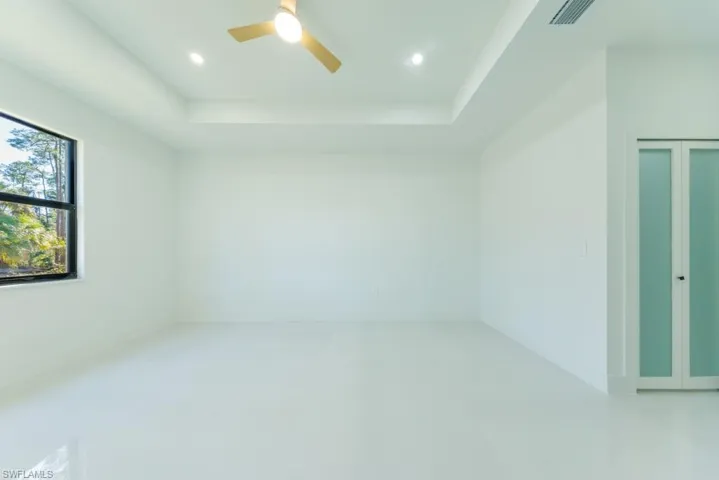 Spare room with a tray ceiling, recessed lighting, and ceiling fan