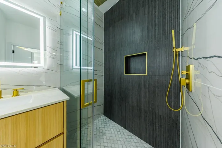 Full bathroom with a marble finish shower and vanity