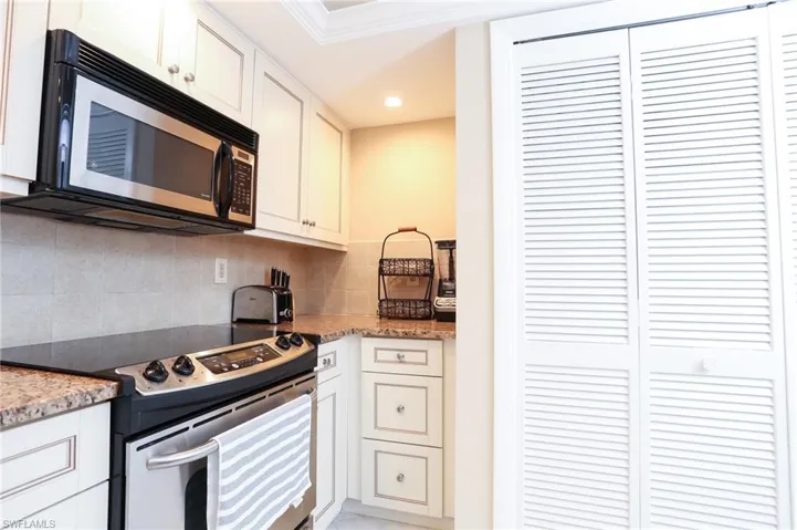 Kitchen with white cabinets, tasteful backsplash, appliances with stainless steel finishes, and recessed lighting