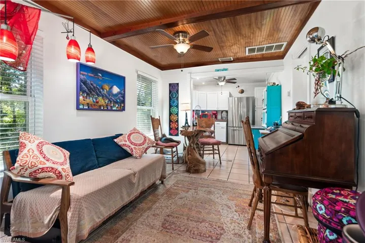 Office area featuring light tile patterned floors, wood ceiling, beamed ceiling, and ceiling fan