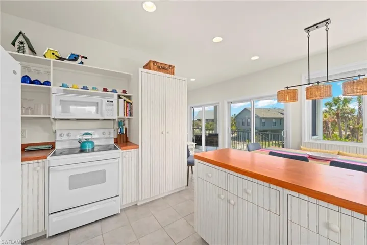 Kitchen featuring pendant lighting, open shelves, recessed lighting, a peninsula, and light tile patterned floors