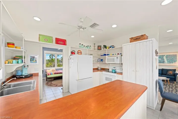 Kitchen featuring open shelves, appliances with stainless steel finishes, light tile patterned floors, white cabinetry, and recessed lighting