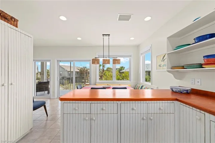 Kitchen featuring open shelves, appliances with stainless steel finishes, a ceiling fan, a peninsula, and light tile patterned flooring